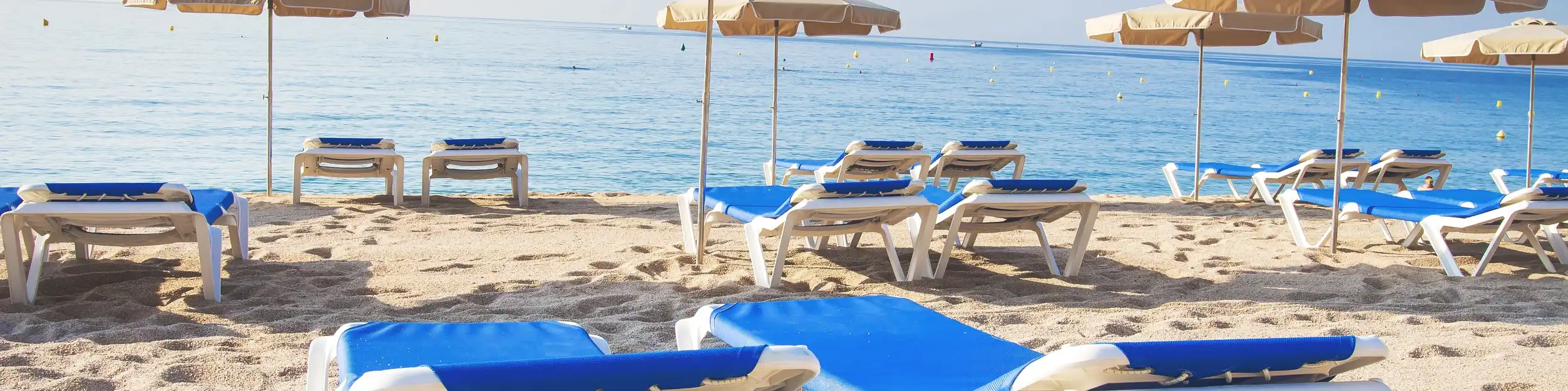 Strand mit Liegen und Sonnenschirmen